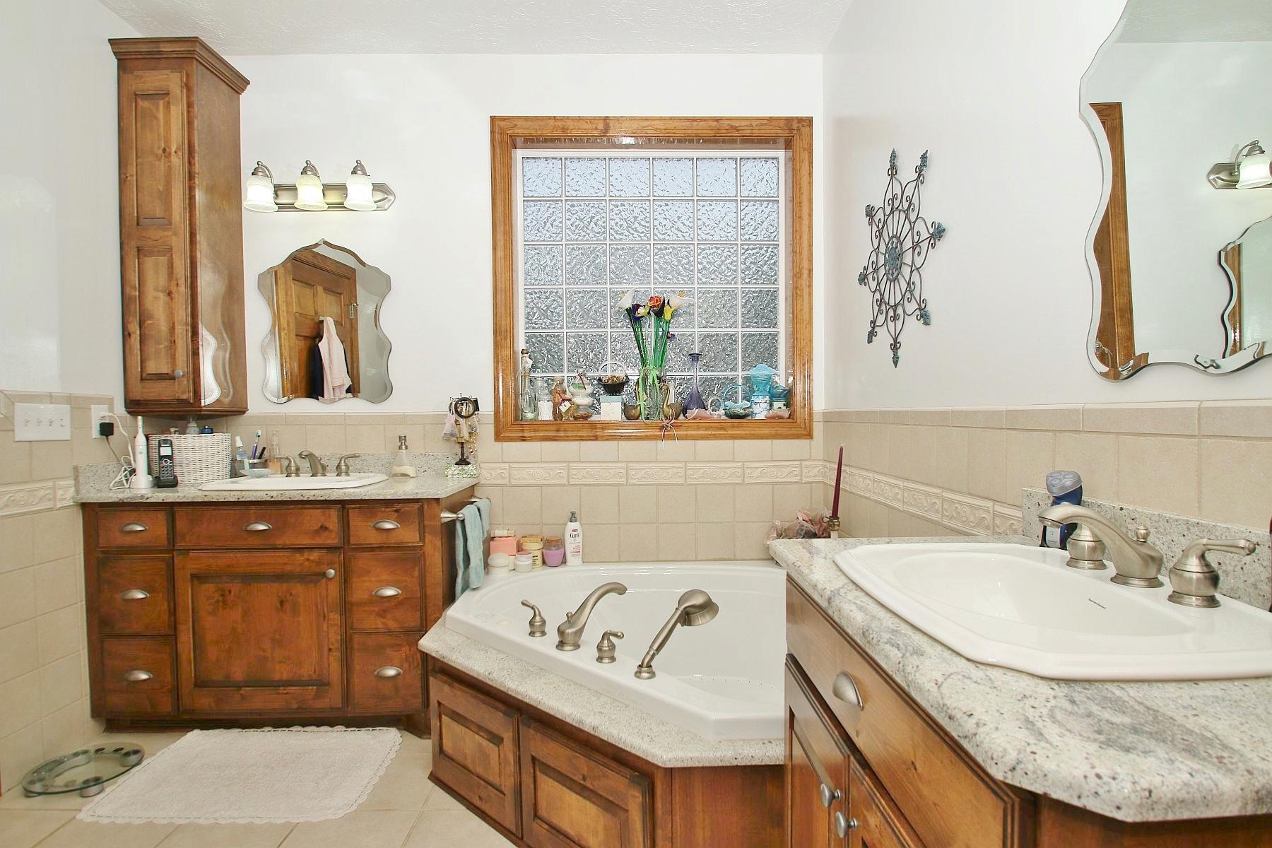 7988 Mayland Road Roanoke, VA 24014 - Photo 40 of 63 a bathroom with a granite countertop sink a mirror a vanity and bathtub