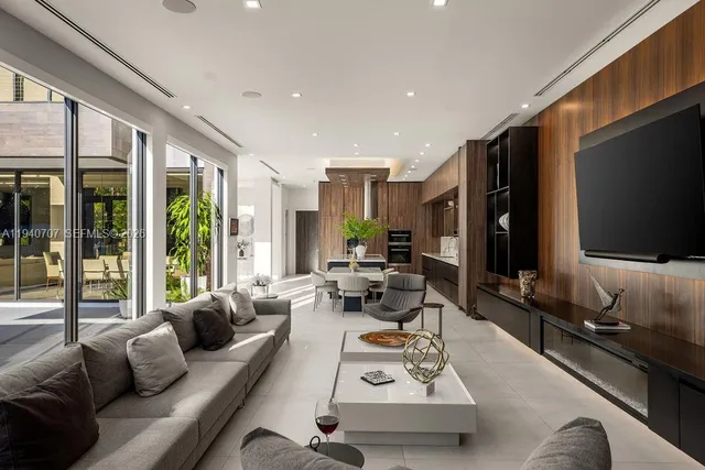 a living room with furniture flat screen tv and a large window