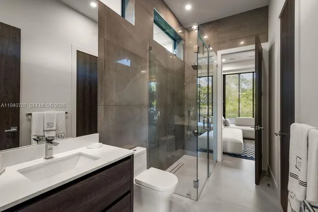 a bathroom with a sink a toilet and shower