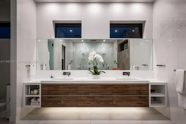 a bathroom with double vanity and a mirror