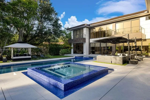 a view of a house with swimming pool and sitting area