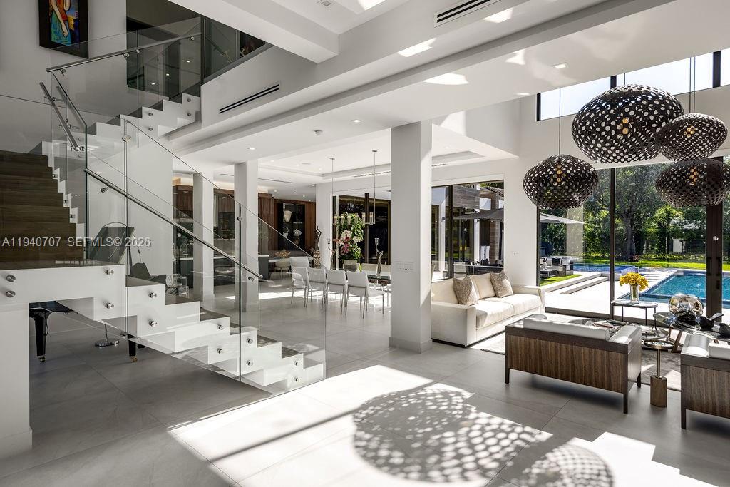 6850 Southwest 73rd Court Miami, FL 33143 - Photo 7 of 52 a living room with lots of furniture and a chandelier