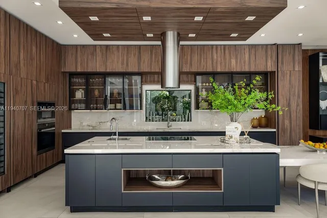 a living room with stainless steel appliances kitchen island granite countertop a stove and a sink