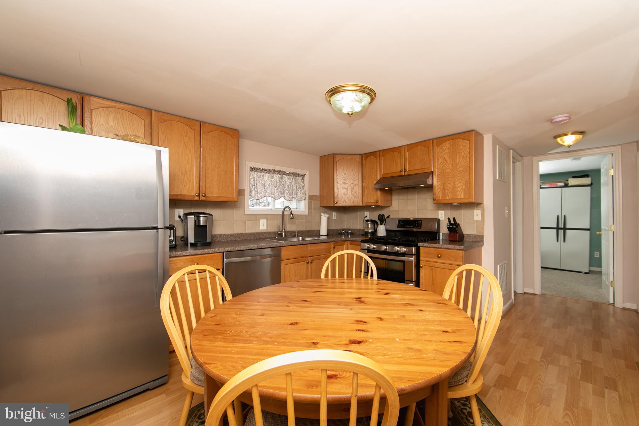 614 West 5th Street Palmyra, NJ 08065 - Photo 11 of 30 a kitchen with stainless steel appliances granite countertop a dining table chairs refrigerator and sink