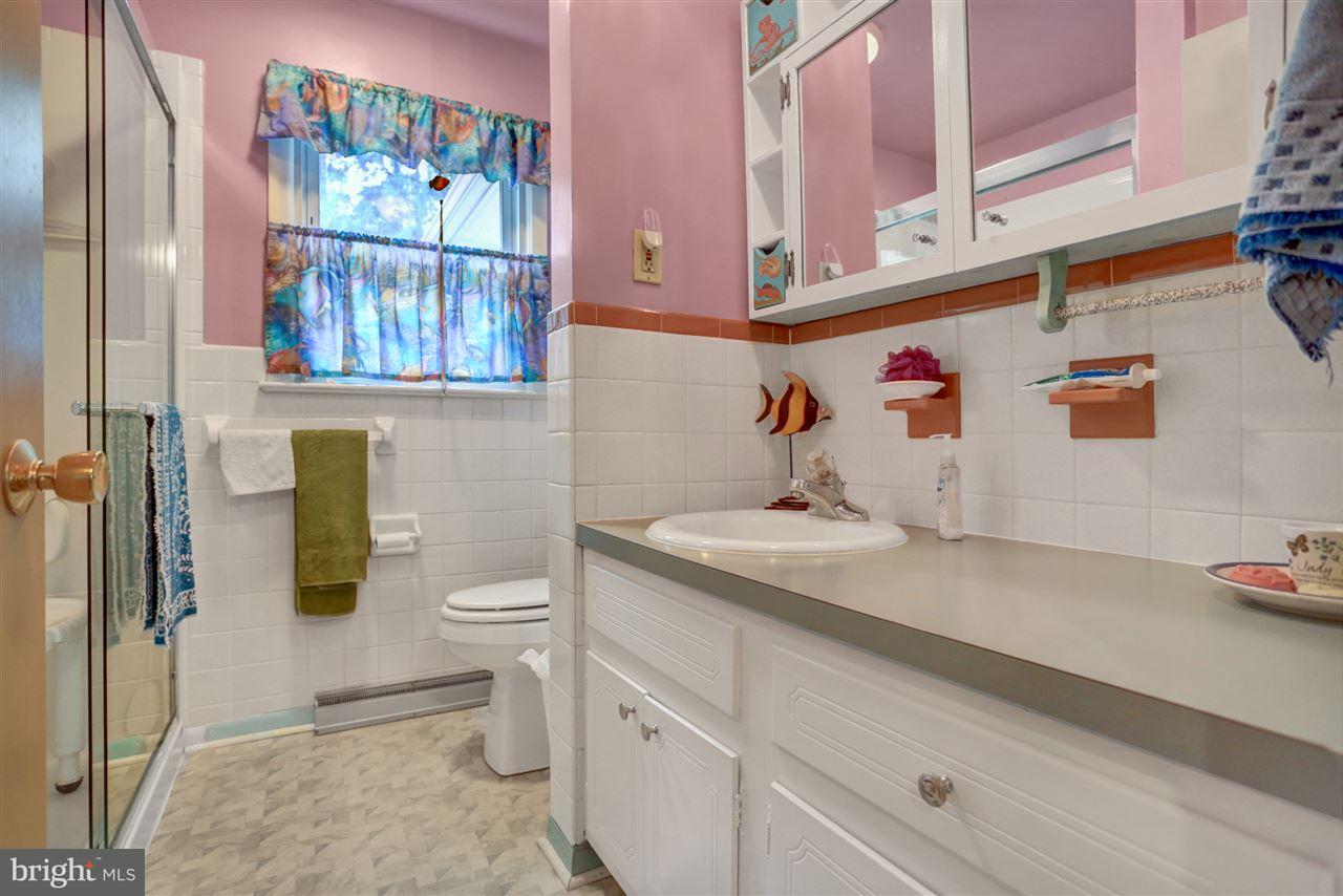 2238 Sycamore Road York, PA 17408 - Photo 21 of 32 a bathroom with a granite countertop sink a toilet and a shower curtain