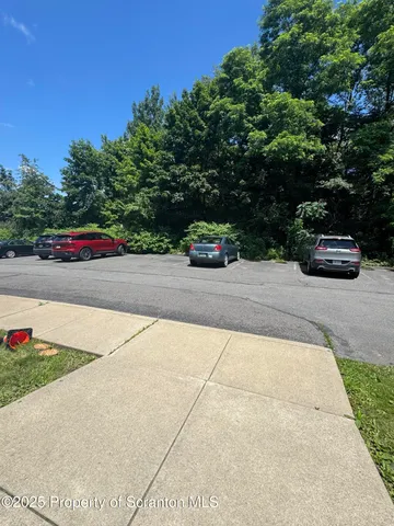 a view of backyard with swimming pool and trees