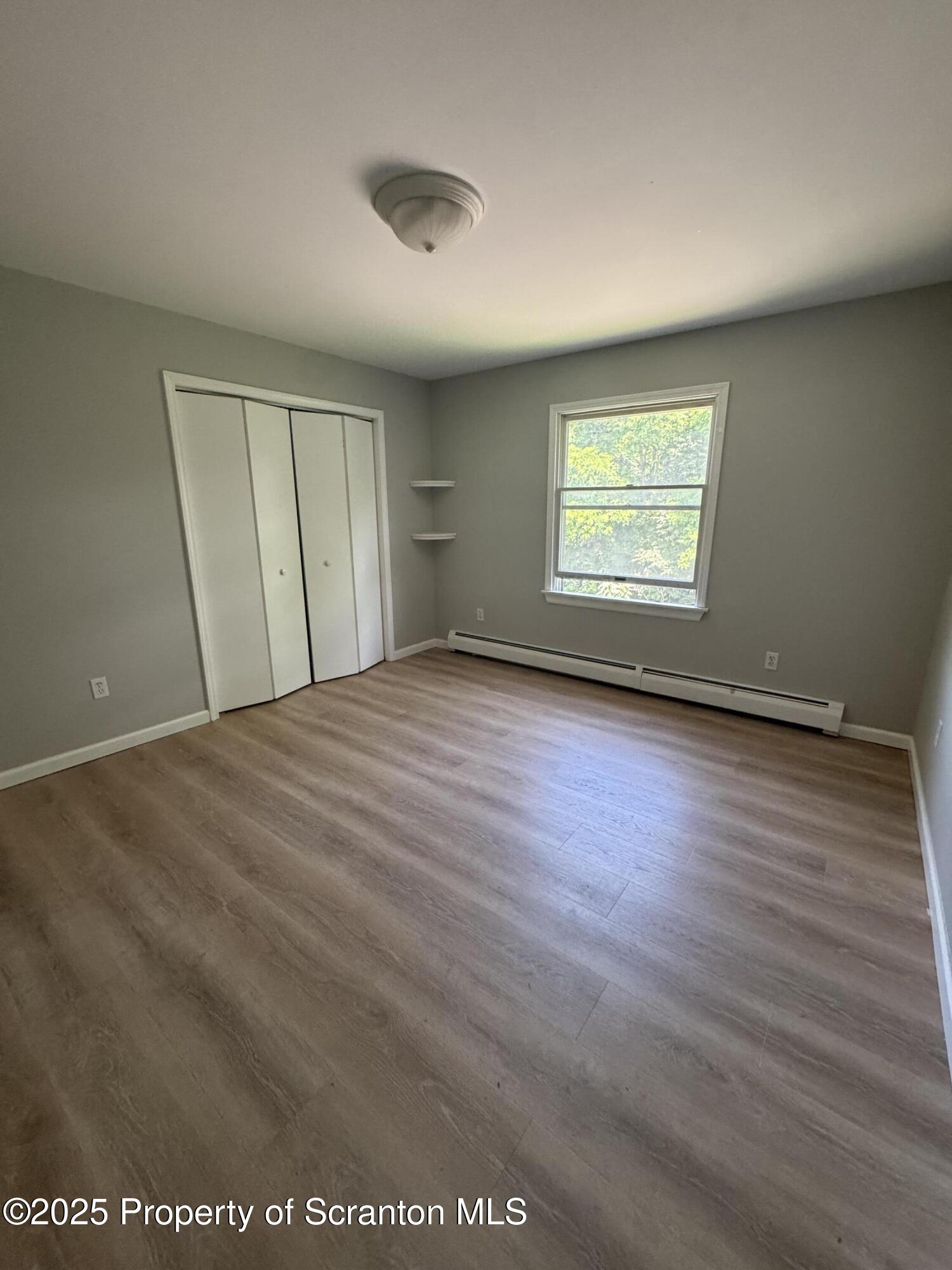 131 Smith Street, Unit 6 Dunmore, PA 18512 - Photo 4 of 13 an empty room with wooden floor and windows