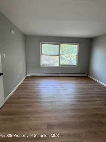 wooden floor in an empty room with a window