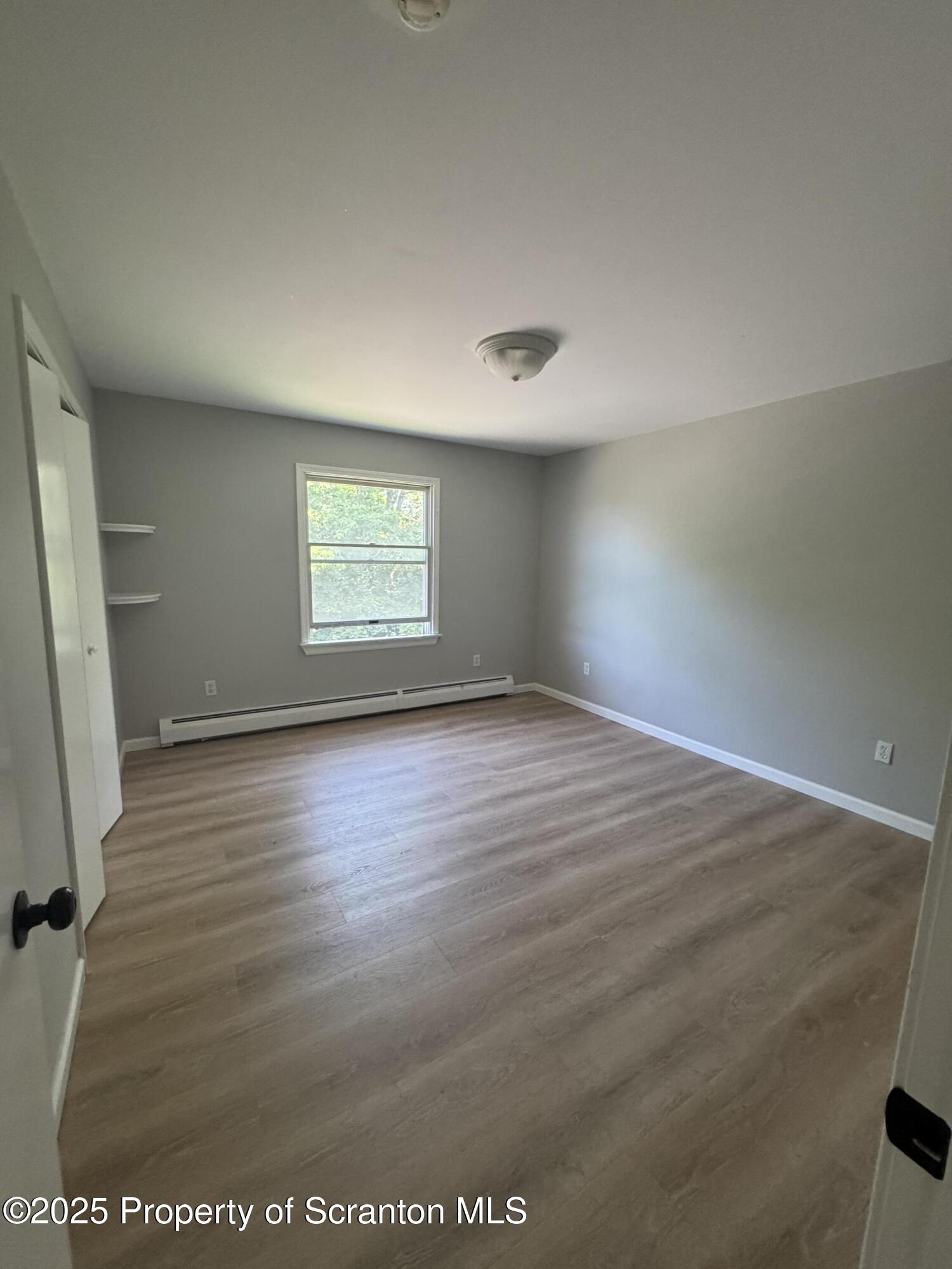 131 Smith Street, Unit 6 Dunmore, PA 18512 - Photo 8 of 13 an empty room with wooden floor and windows