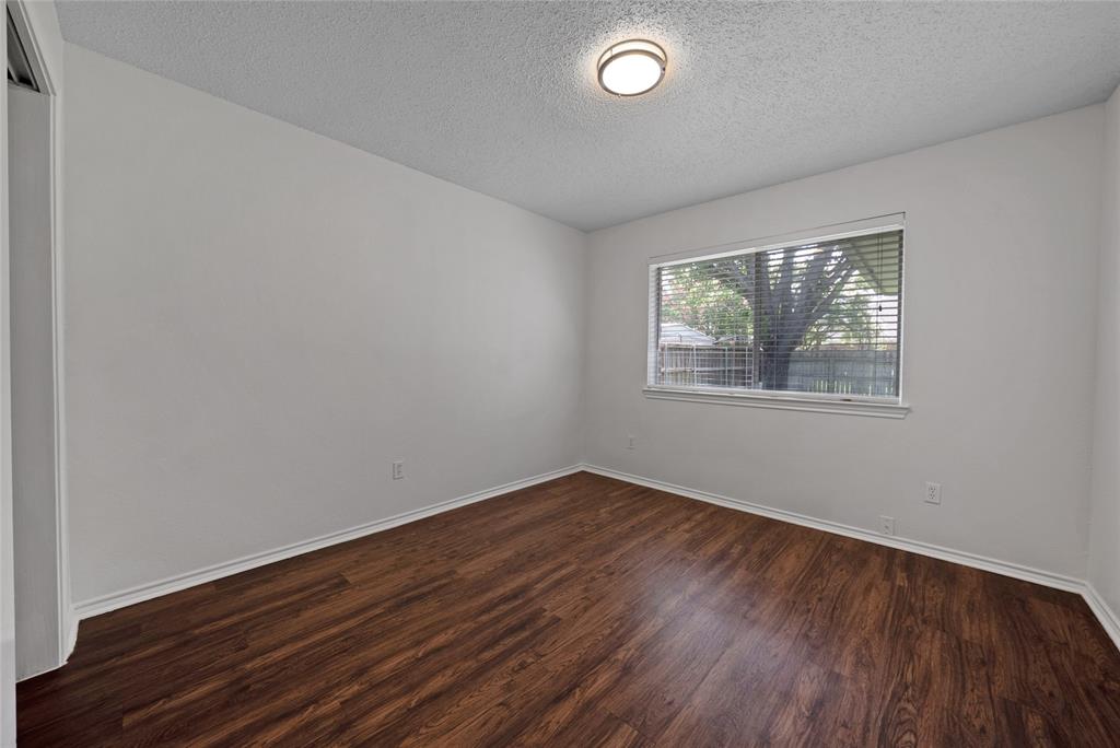 2910 Chisholm Trail Corinth, TX 76210 - Photo 22 of 30 an empty room with wooden floor and windows