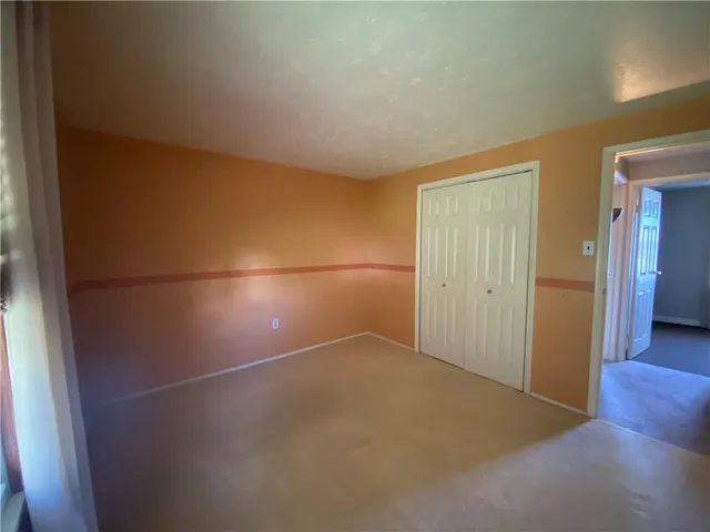 an empty room with wooden floor and mirror