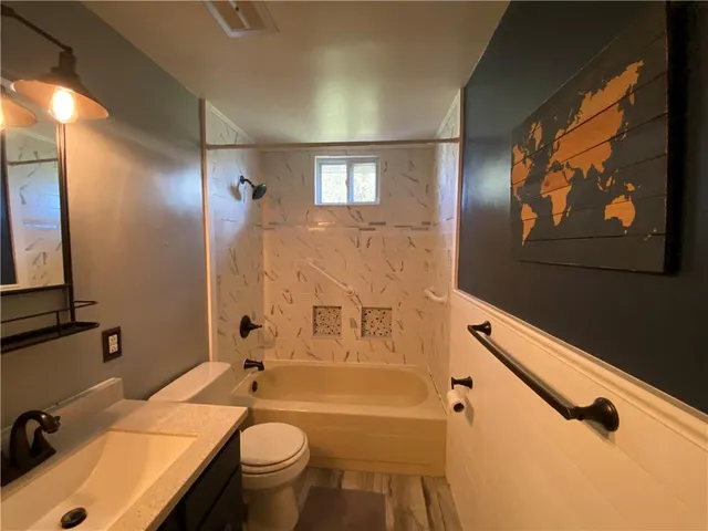 a bathroom with a sink a toilet and shower