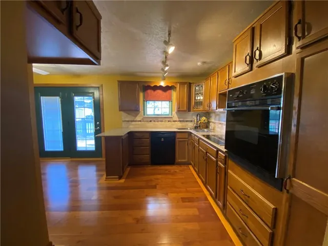 a large kitchen with stainless steel appliances granite countertop a stove a sink and a refrigerator