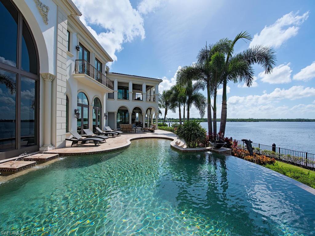 2615 Tarpon Road Naples, FL 34102 - Photo 17 of 20 a view of a swimming pool with chairs and table in front of house