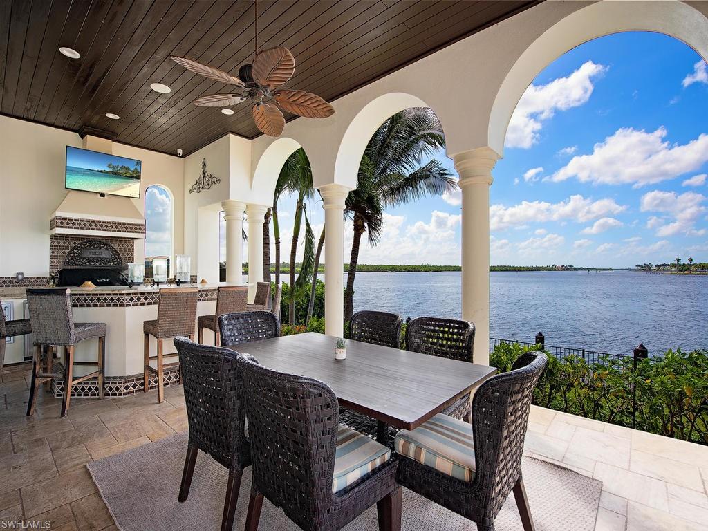 2615 Tarpon Road Naples, FL 34102 - Photo 10 of 20 a view of a dining table and chairs with an umbrella