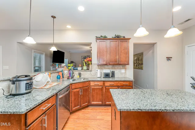 a kitchen with stainless steel appliances granite countertop white cabinets and a stove top oven