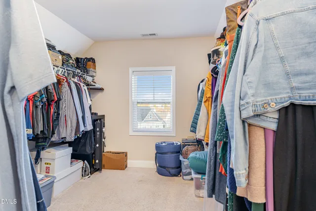 a bedroom with a bed and a flat tv screen on dresser