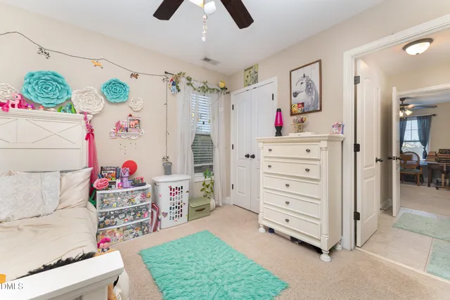 a children room with furniture and a fan