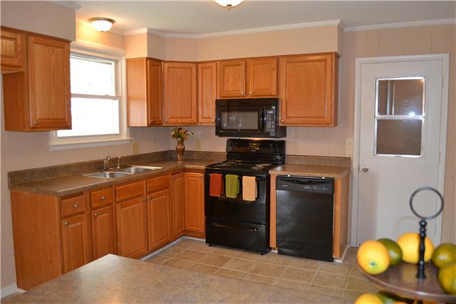 A wiindow over the sink provides an unobstructed view of the large, level fenced in backyard.
