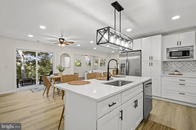 a kitchen with stainless steel appliances granite countertop a sink a stove and a refrigerator