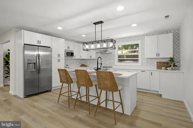 a kitchen with stainless steel appliances granite countertop a kitchen island a stove a table and chairs in it