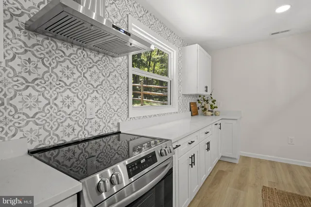 a kitchen with stainless steel appliances granite countertop a sink a stove and a refrigerator