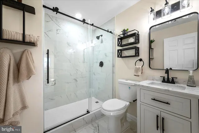 a bathroom with a sink a toilet and shower