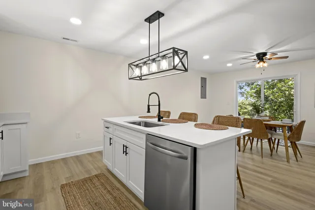 a kitchen with a sink cabinets and wooden floor