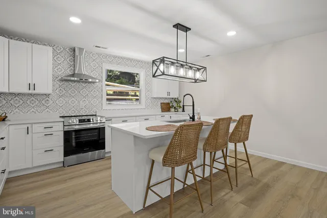 a kitchen with stainless steel appliances a sink dishwasher a stove a microwave oven with cabinets and wooden floor