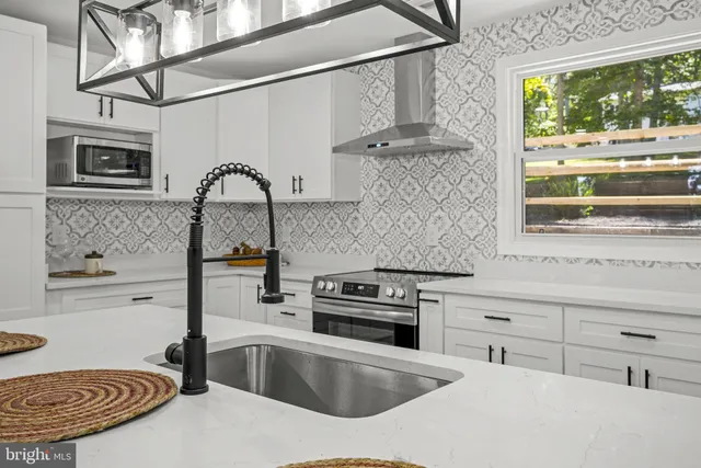 a kitchen with stainless steel appliances granite countertop a dining table chairs refrigerator and cabinets