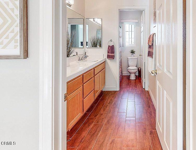 14145 Rock Place Riverside, CA 92503 - Photo 22 of 30 a en suite bathroom with a sink mirror and a hardwood