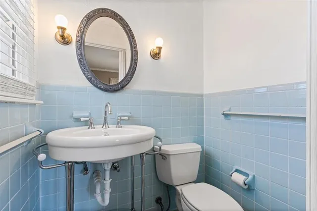 a bathroom with a sink a toilet and a mirror