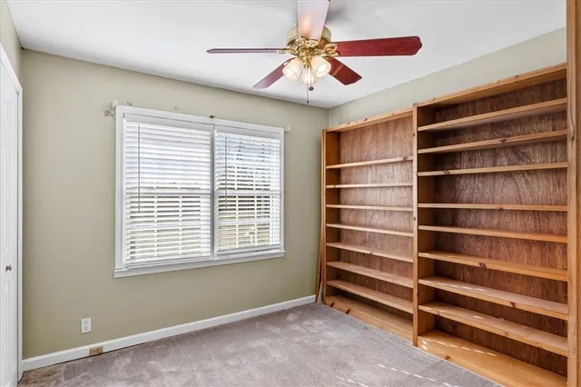 a view of an empty room with a window and a ceiling fan