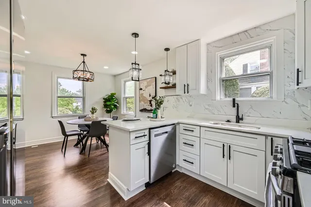 a kitchen with white cabinets sink and dining table
