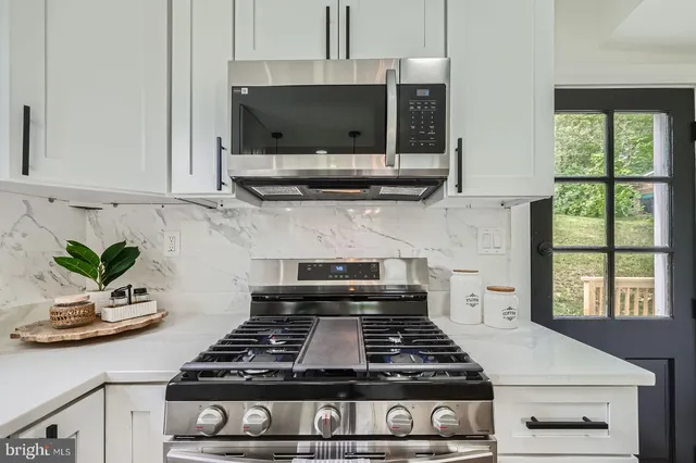 a kitchen with a stove and a white cabinets