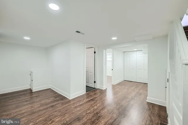 a view of an empty room with wooden floor