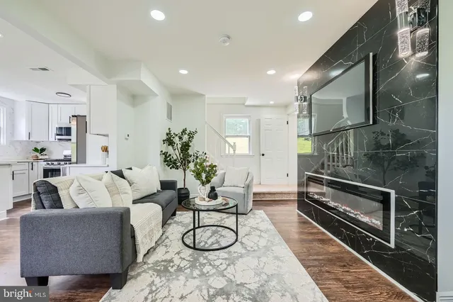 a living room with furniture a rug and white walls