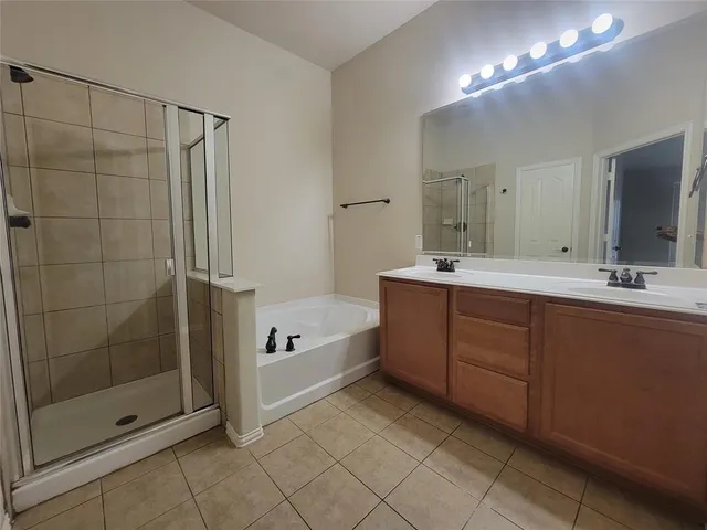 a spacious bathroom with a shower sink and mirror