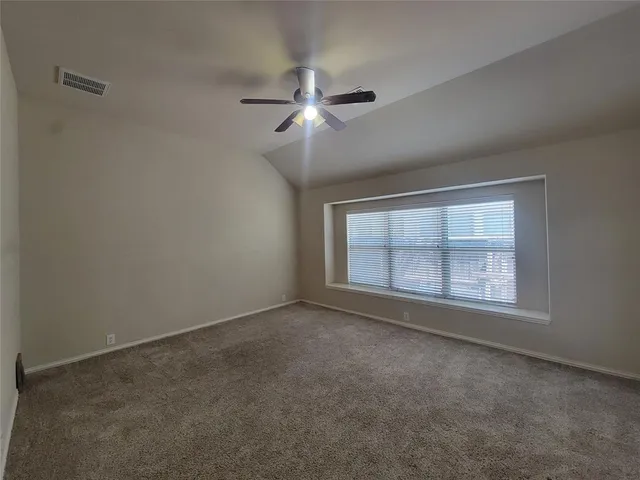 an empty room with a window and a fan