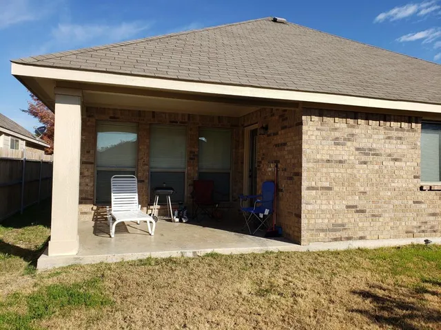 a view of a porch with a table and chairs
