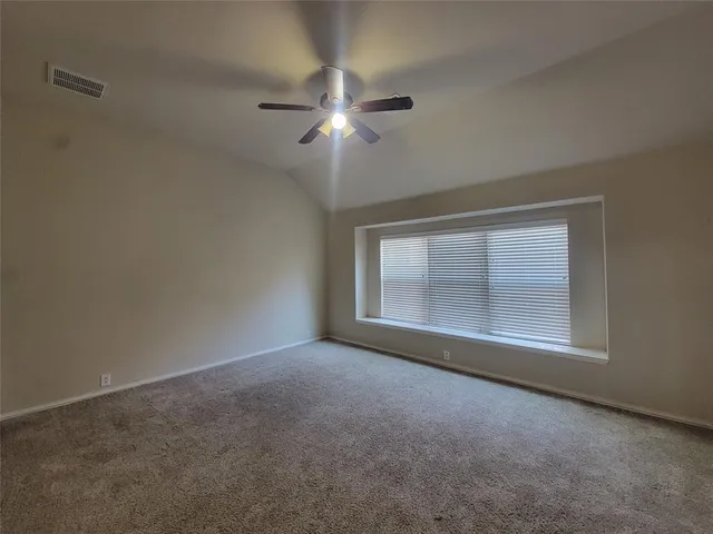 a view of empty room with fan and window