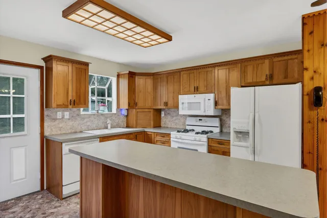 a kitchen with stainless steel appliances granite countertop a refrigerator a stove and a sink with wooden floor