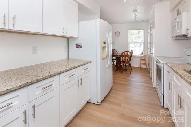 a kitchen with granite countertop cabinets a sink a counter space and stainless steel appliances