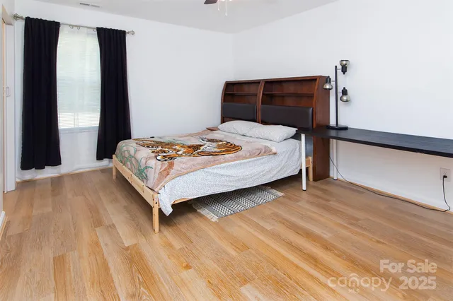 a bedroom with a bed lamp and a large window