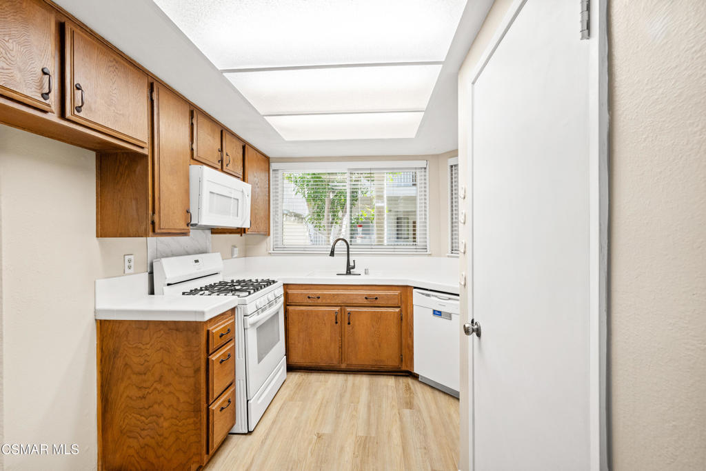 3354 Darby Street, Unit 313 Simi Valley, CA 93063 - Photo 11 of 30 a kitchen with a sink a window and cabinets
