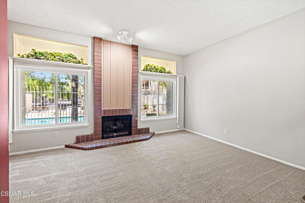 3354 Darby Street, Unit 313 Simi Valley, CA 93063 - Photo 16 of 30 an empty room with fireplace and windows