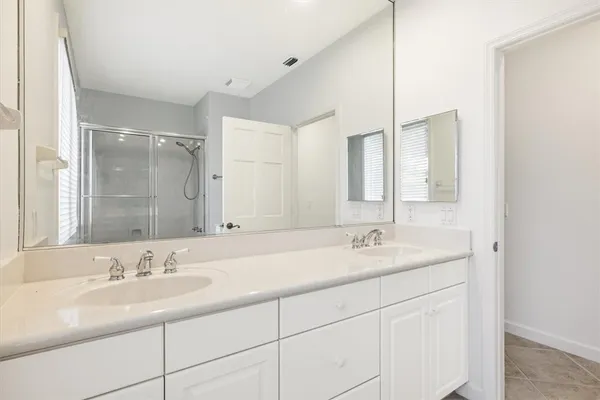 a bathroom with double sink and a mirror
