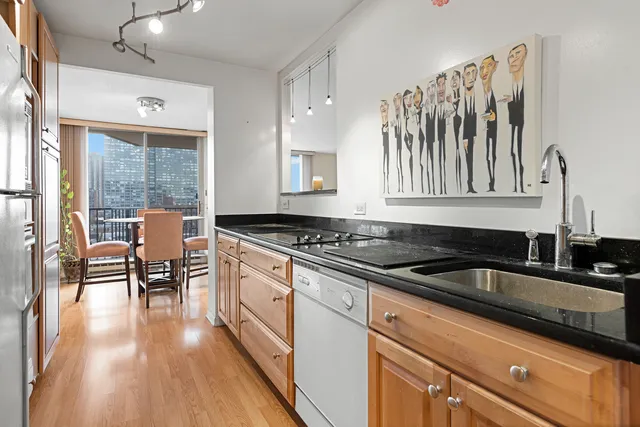 a kitchen with granite countertop a stove a sink and wooden floors
