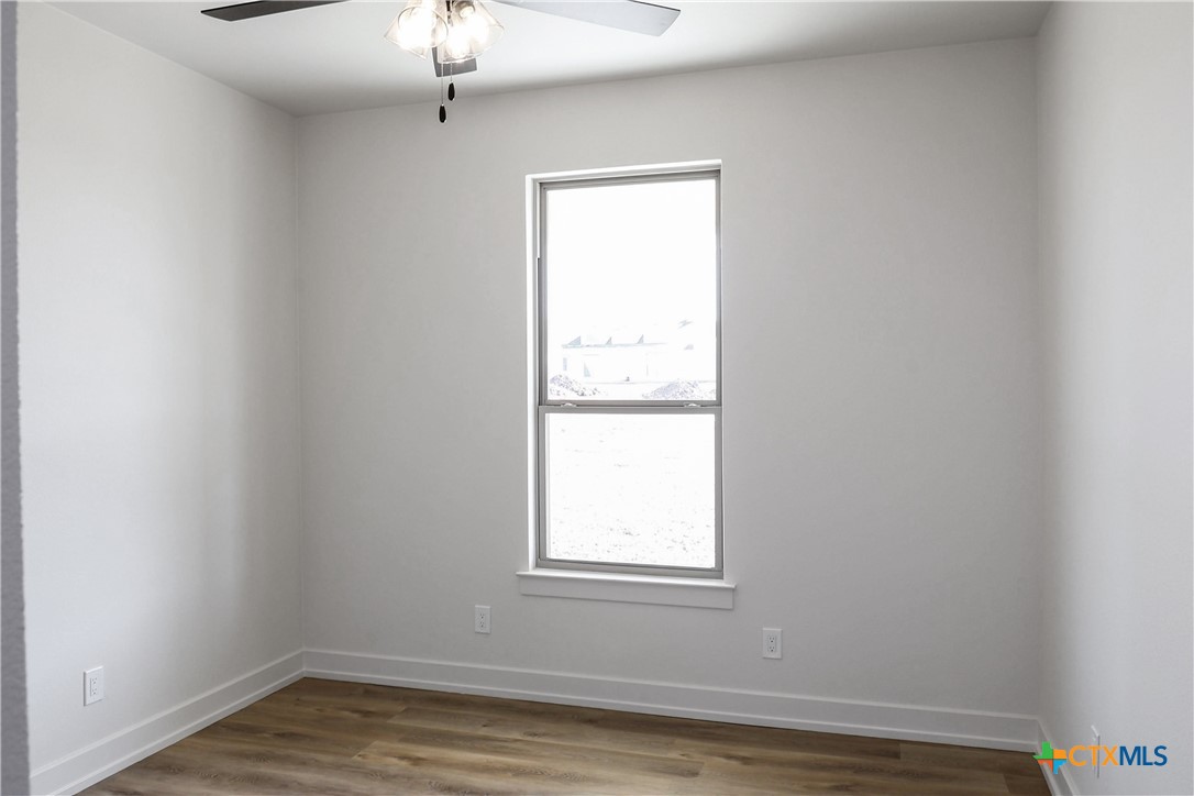 16026 Honey Ridge Drive Holland, TX 76534 - Photo 13 of 27 a view of an empty room with wooden floor and a window