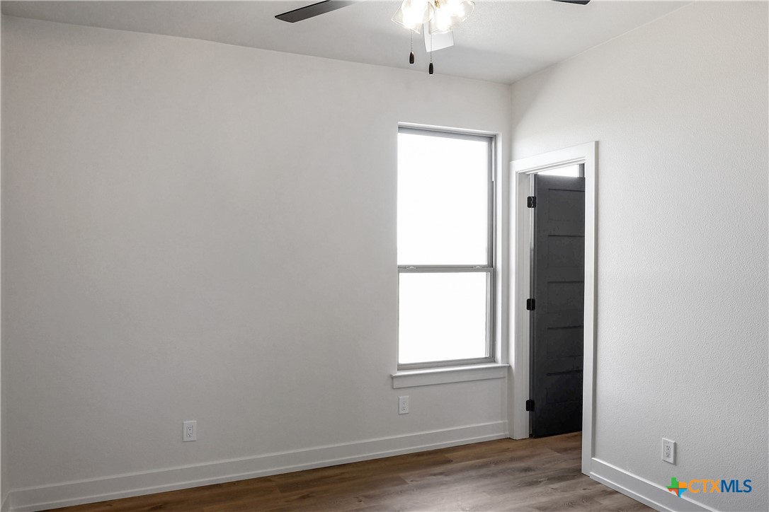 16026 Honey Ridge Drive Holland, TX 76534 - Photo 15 of 27 an empty room with wooden floor cabinet and windows